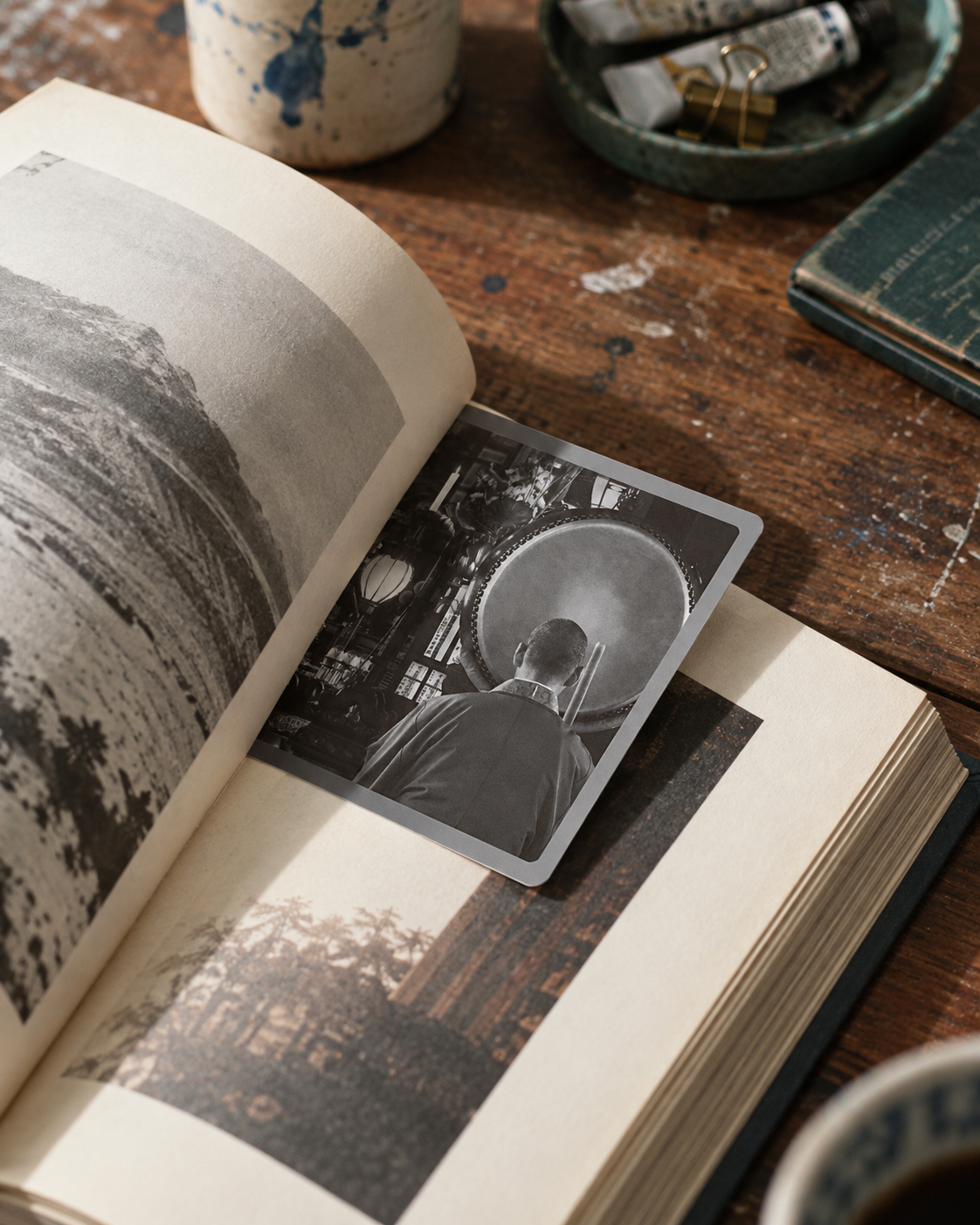 The Tokyo Atmosphere · Stillness, a small fragrance card tucked between the pages of an open book as a bookmark.